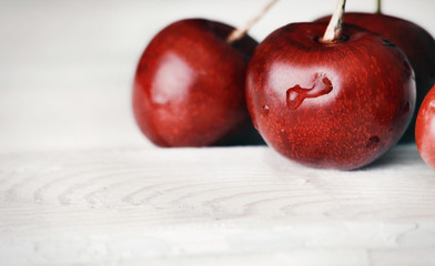 ripe delicious cherries on white wooden table with water drops m