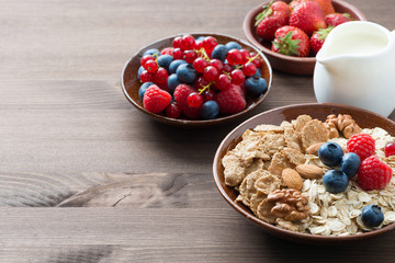 oatmeal and muesli in a bowl, fresh berries and milk