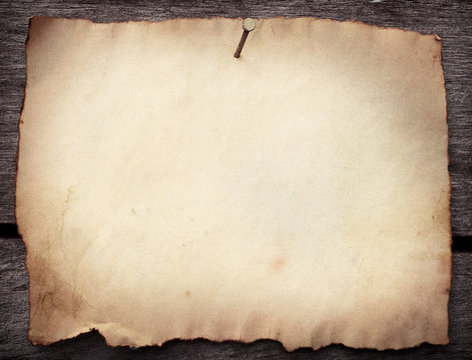 Old paper nailed to a grunge wooden background