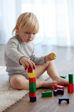 Toddler playing with wooden blocks