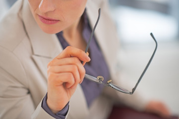 Closeup on business woman holding eyeglasses