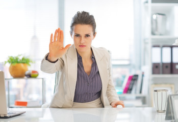 Business woman in office showing stop gesture