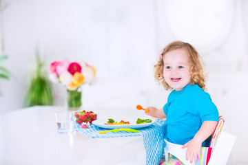 Little pretty girl eating salad for lunch