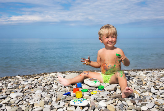 Kid soiled by paints on beach