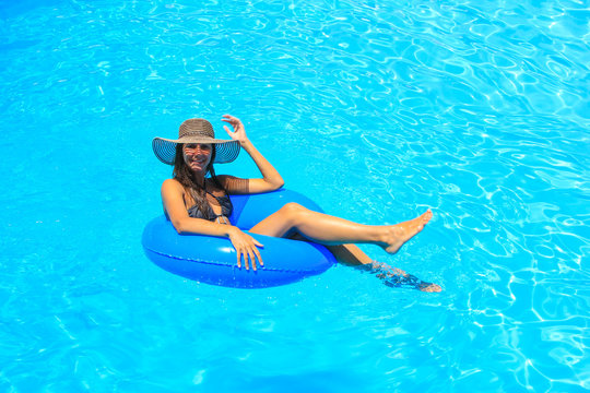 Young woman wearing a straw hat at the pool