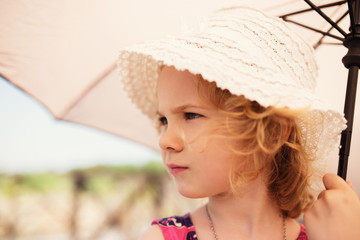 Little cute girl holding an umbrella, close up portrait