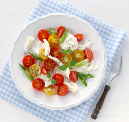 Salad with mozzarella, red and yellow cherry tomatoes