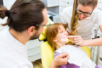 Zahnärzt behandelt Mädchen in Zahnarztpraxis 