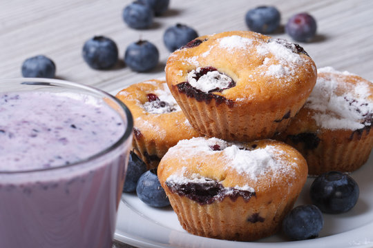 Blueberry muffins on a white plate and a milkshake horizontal