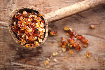 Gum arabic, also known as acacia gum - in  old wooden spoon - 67557111