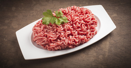 Minced meat over wooden background