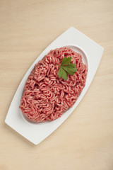Minced meat over wooden background