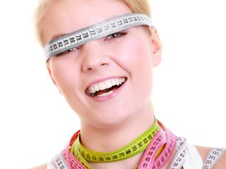 Obsessed fitness woman with a lot of colorful measure tapes