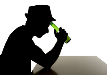 silhouette of alcoholic drunk man drinking beer bottle in abuse