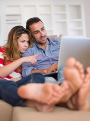 relaxed young couple working on laptop computer at home