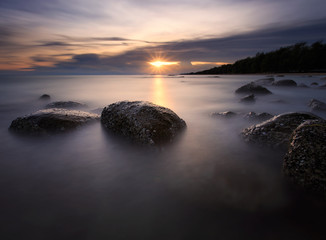 Fototapeta na wymiar Beautiful sunset at the stone beach