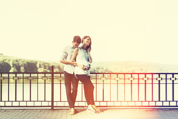 Fototapeta premium Happy and young pregnant couple hugging in nature at the lake. V