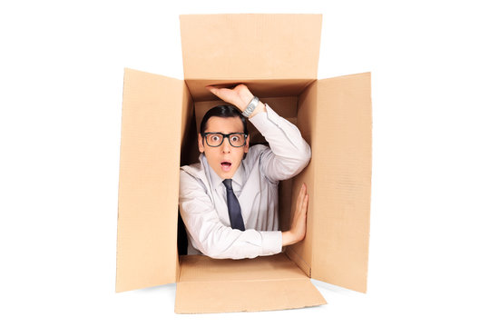 Young businessman trapped in a box