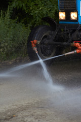 Трактор поливает дорогу