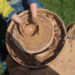 Child works on pottery wheel. top view
