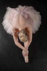 Graceful ballerina bending forward in pink tutu © WavebreakMediaMicro