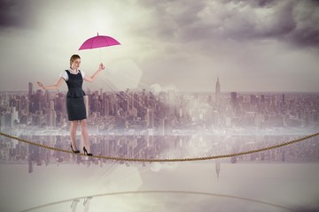 Composite image of pretty redhead businesswoman holding umbrella