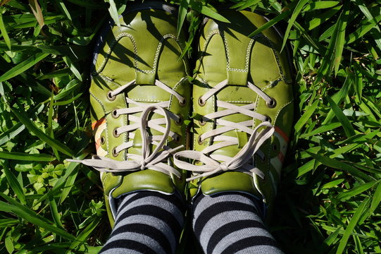 gr&uuml;ne schuhe mit Ringelsocken im gr&uuml;nen Gras