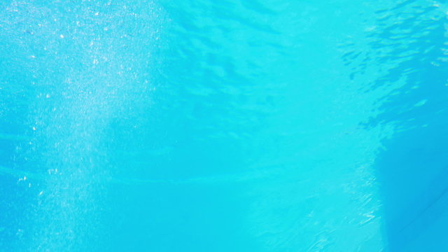 Pretty brunette diving underwater into pool