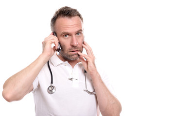 Männlicher Arzt oder Pfleger in weißem Poloshirt telefoniert