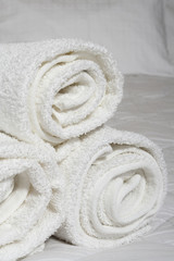 Fototapeta na wymiar Rolled towels on bed .