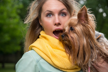 Surprised girl with her small dog in city park