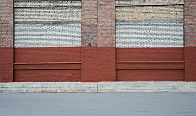 Red and white brick wall with the strip of asphalt