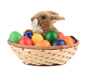 Fluffy foxy rabbit in basket with Easter eggs.