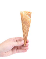 Hand holds empty ice cream corn.