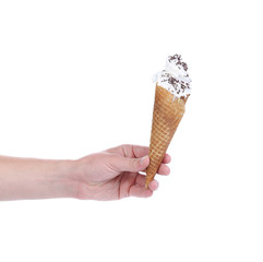 Hand holds cone vanilla ice cream.