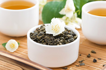 dry green tea with jasmine and cups of tea