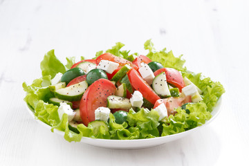 green salad with vegetables on white wooden table