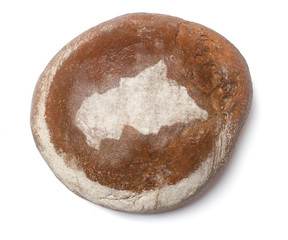 A loaf of fresh bread covered with rye flour in the shape of Cen