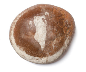 A loaf of fresh bread covered with rye flour in the shape of Bah