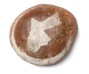 A loaf of fresh bread covered with rye flour in the shape of Jor