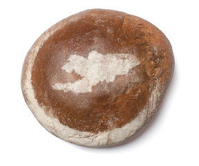 A loaf of fresh bread covered with rye flour in the shape of Kyr