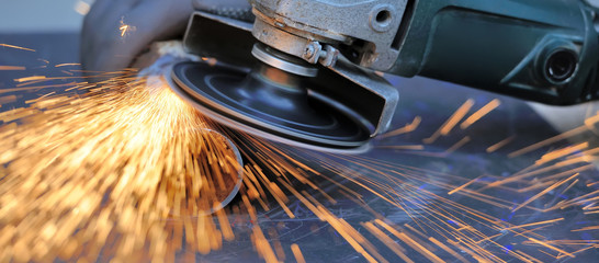 Worker cutting metal with grinder