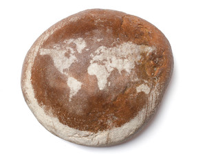 A loaf of fresh bread covered with rye flour in the shape of the
