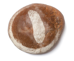 A loaf of fresh bread covered with rye flour in the shape of How