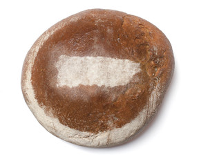 A loaf of fresh bread covered with rye flour in the shape of Pue