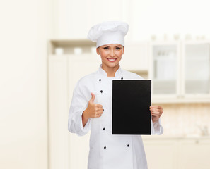 smiling female chef with black blank paper