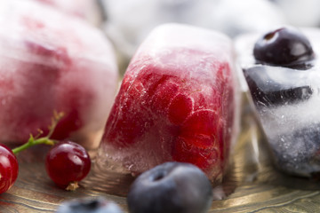 Fresh berry fruits frozen in ice cubes