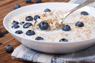 Tasty breakfast of oatmeal with blueberries and milk