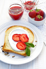 Toast with creamy cheese, fresh strawberry and mint
