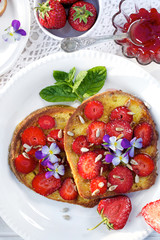 French toasts with fresh strawberries and edible flowers
